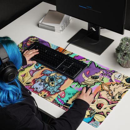 Gamer with blue hair using a large Drippy Pokémon Skull Collage mousepad beneath a black keyboard and mouse on a white desk.
