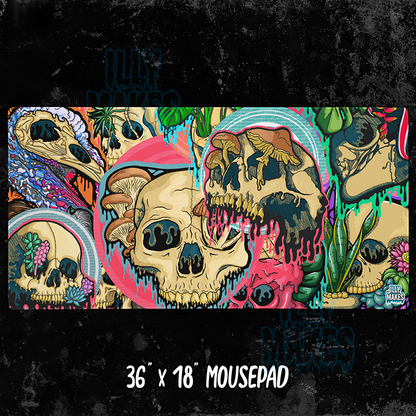 Illymakes gaming mousepad with a colorful collage of dripping skulls, mushrooms, and florals, shown with a keyboard, mouse, and headphones. The text shows 36"x18" MOUSEPAD below.